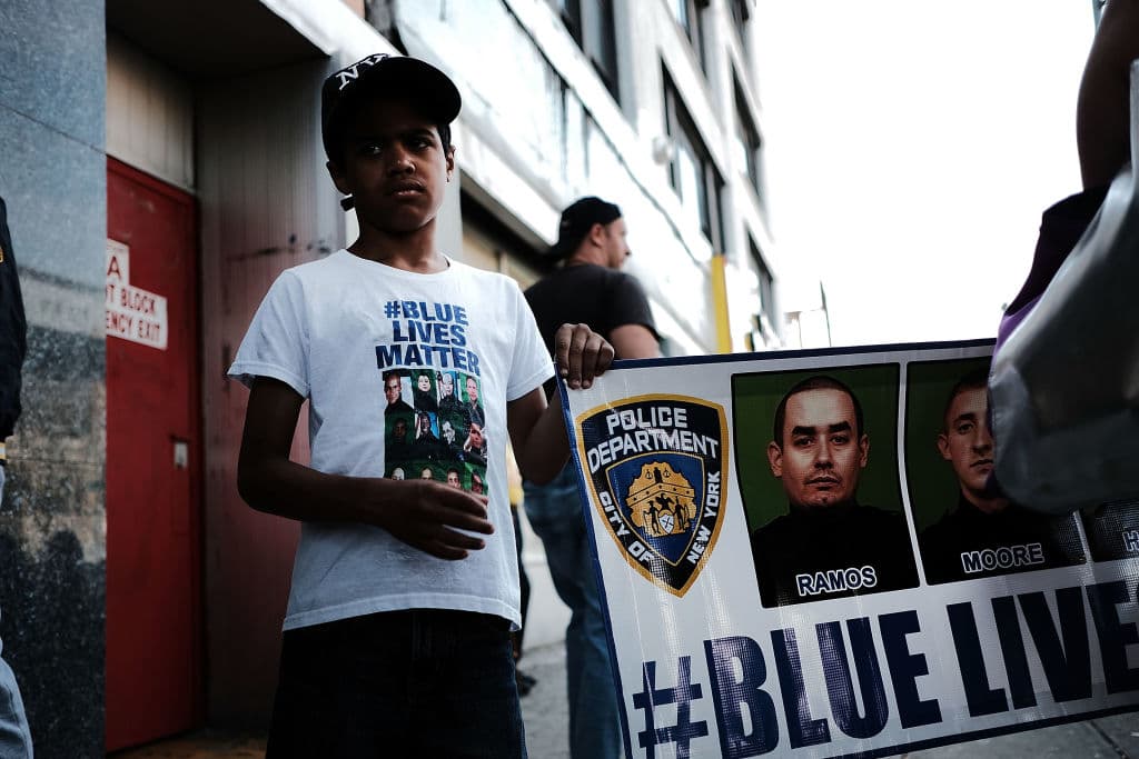 "Las vidas azules importan", se lee en una de las pancartas frente a la iglesia. Familia fue la primera policía asesinada en la ciudad de Nueva York desde los ataques del 11 de septiembre de 2001. (Spencer Platt/Getty Images)