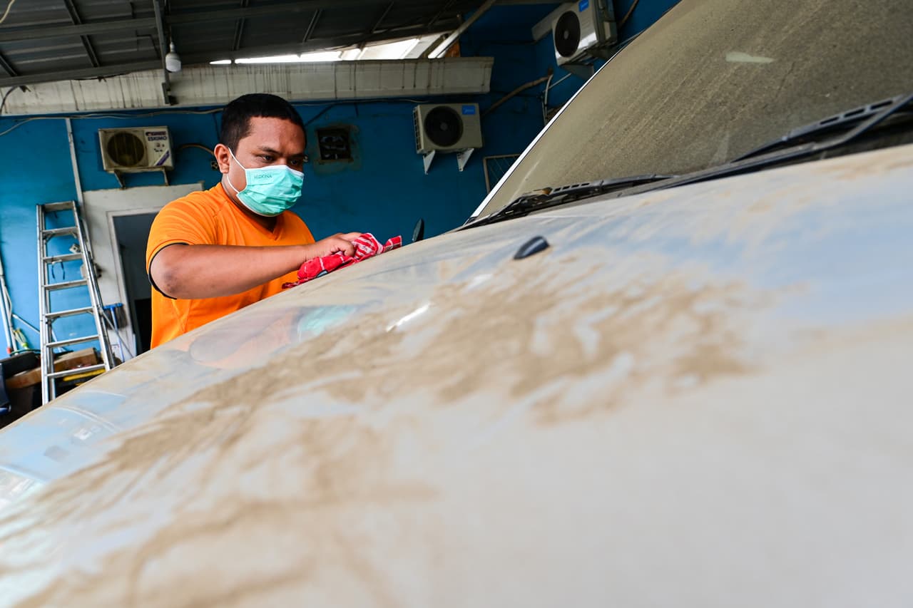 Un hombre limpia la ceniza volcánica de la erupción del monte Anak Krakatau de su automóvil en Bandar Lampung, Indonesia, el domingo 6 de septiembre de 2026.