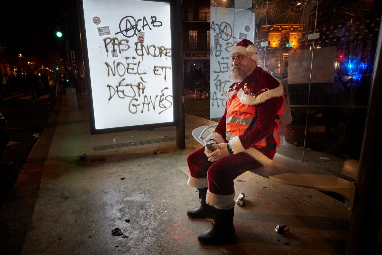 Un manifestante vestido de Santa Claus toma un descanso durante una protesta contra el presidente Emmanuel Macron en París, Francia. 17 de diciembre de 2019.