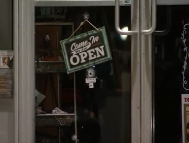 El impacto de una bala en la puerta de un negocio cercano.
