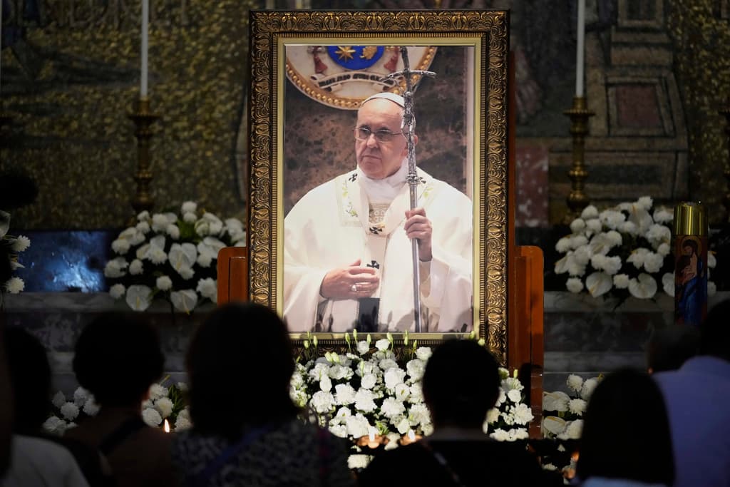 Católicos encienden velas frente a un retrato del fallecido papa Francisco en la Catedral de Manila, Filipinas, este martes 22 de abril de 2025.