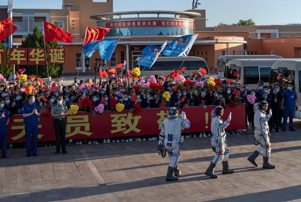 En una ceremonia previa al despegue, los tres astronautas vestidos con sus trajes espaciales, saludaron a un grupo de simpatizantes y trabajadores del centro espacial.