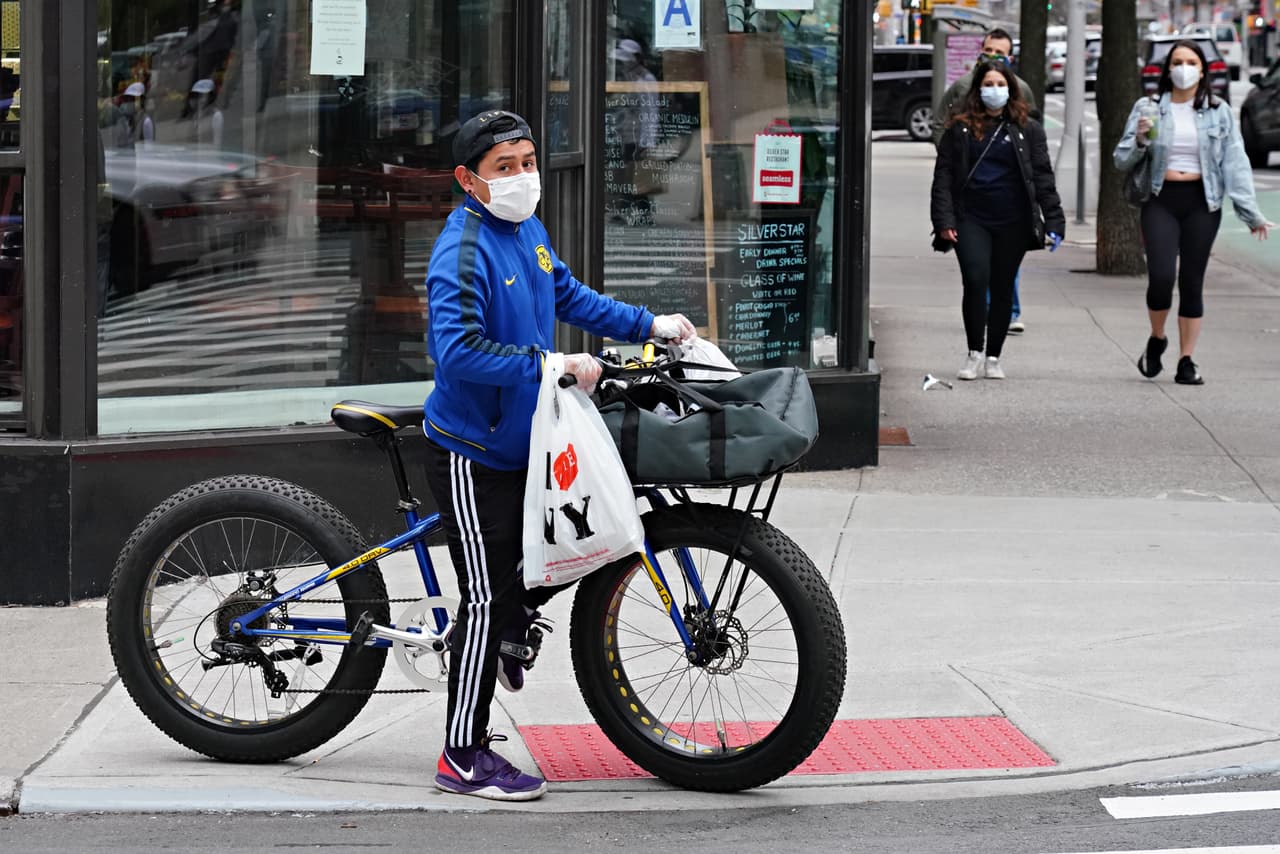 Los repartidores de alimentos son las pocas personas que aún se pueden ver deambulando por las calles vacías de Nueva York.