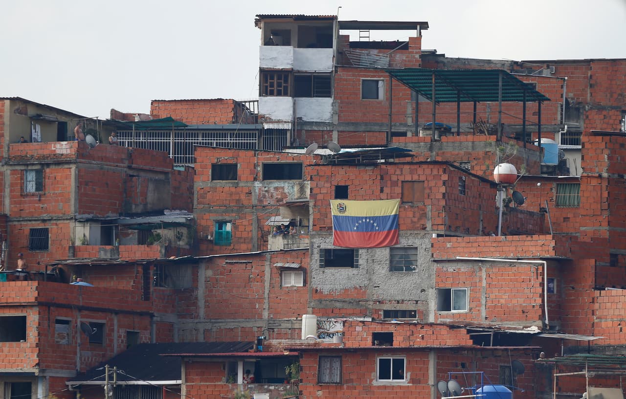 Una bandera de Venezuela fue guindada en la ventana de una vivienda en la popular barriada de Caracas, donde los vecinos de la zona protestaron y luego se enfrentaron a funcionarios de seguridad que los reprimían.