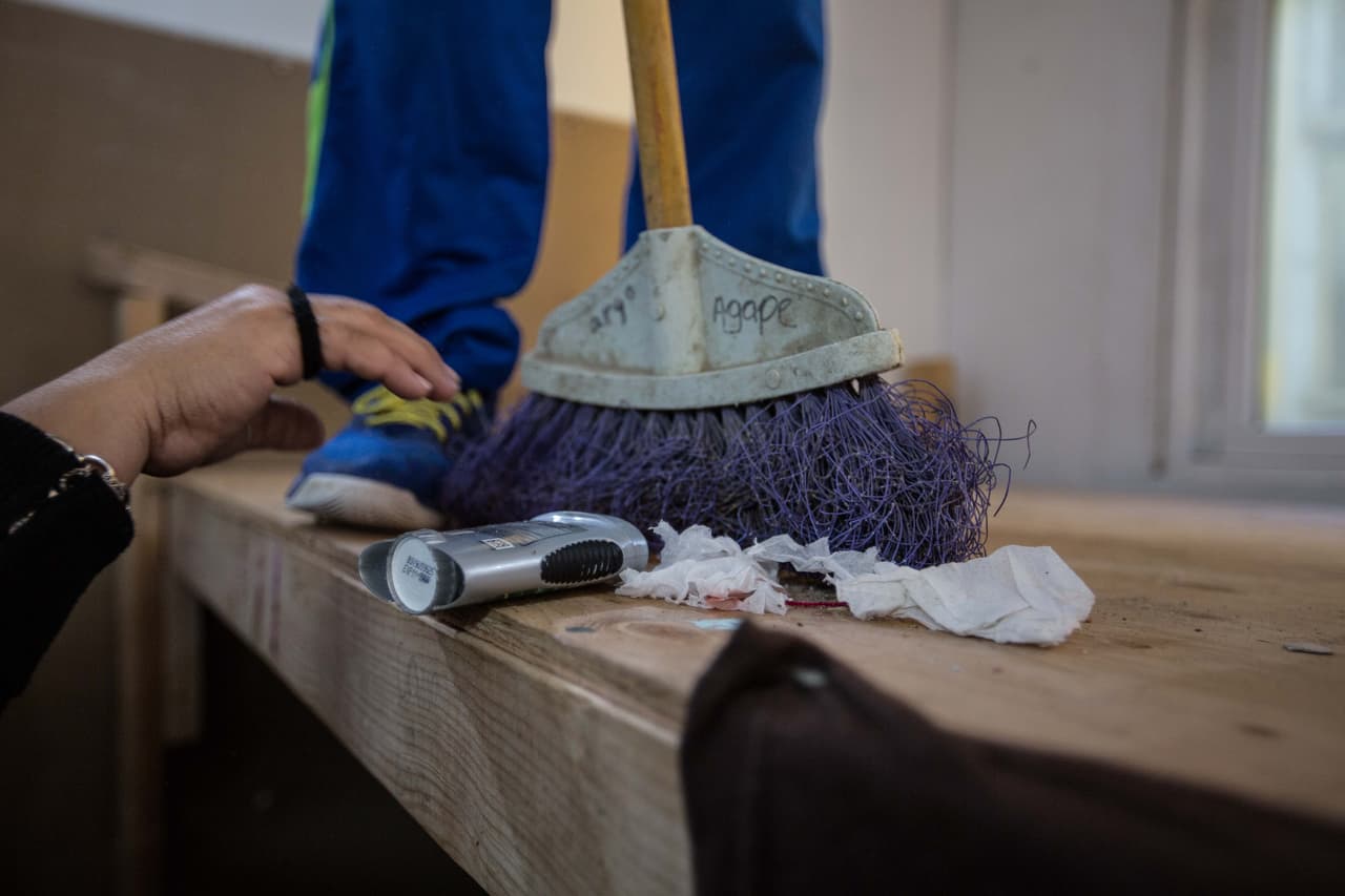 Mientras, Carlos Ayala, el ahijado de 12 años, barre una de las literas antes de su partida. La familia se aseguró de dejar los colchones recogidos y de limpiar el espacio en el que convivieron con otros migrantes durante los últimos meses para que los que vengan lo consigan limpio.