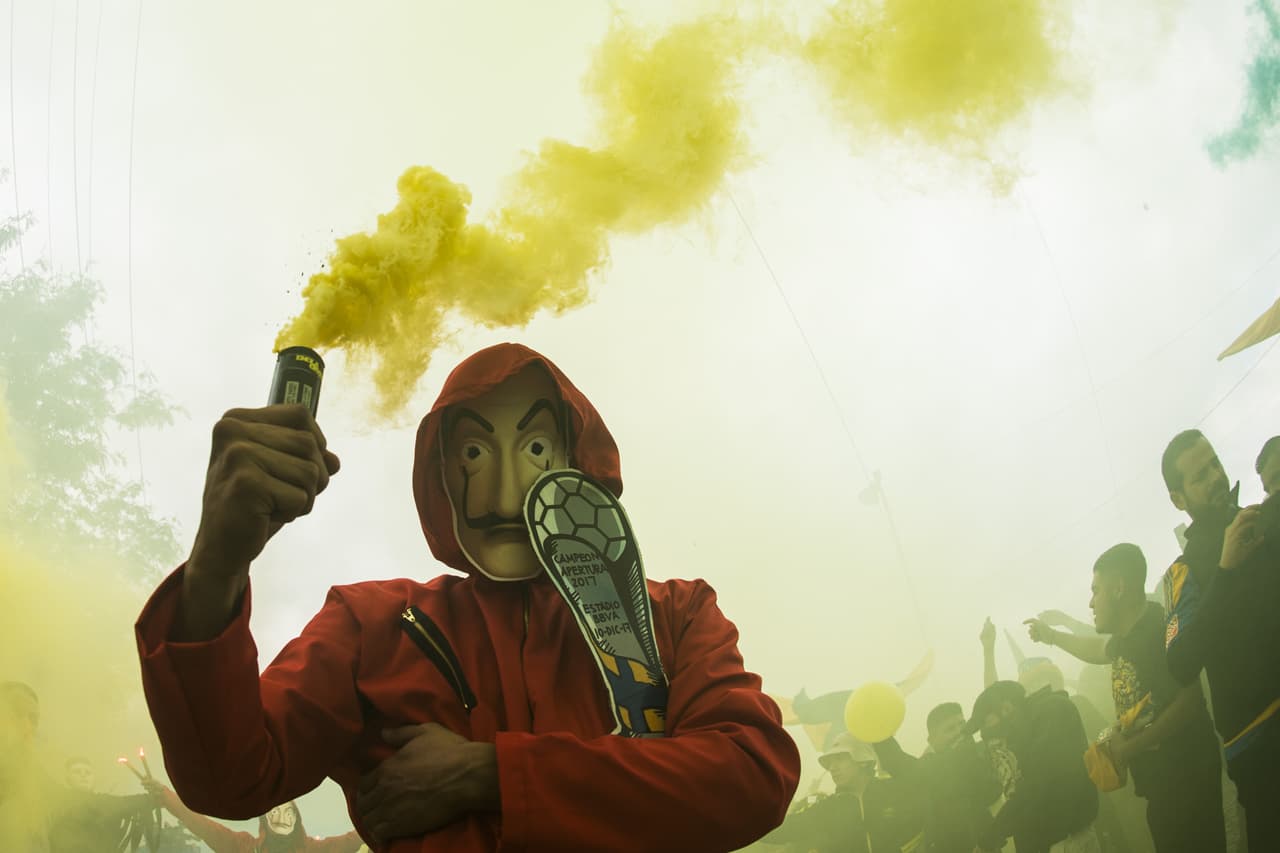 No importa el lugar o la vestimenta. Así se imaginan los aficionados de Tigres, cargando una copa y brillando por sus atuendos entre humo. Esta fue una imagen que nos dejó la Final de Liga MX en el Clásico Regio.
