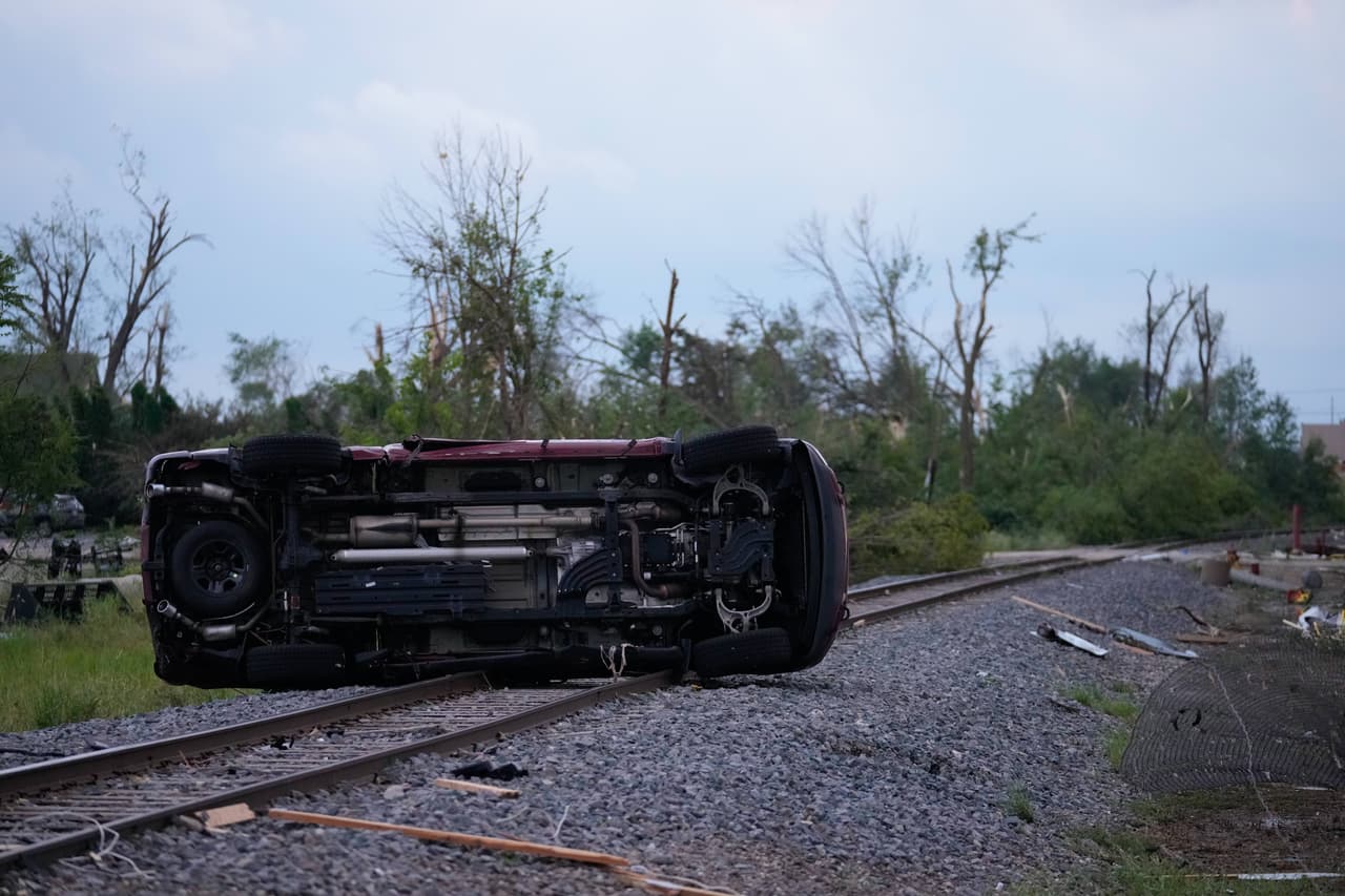 Un automóvil yace sobre las vías del tren tras el paso de un tornado, el lunes 27 de julio de 2026, en Menasha, Wisconsin.