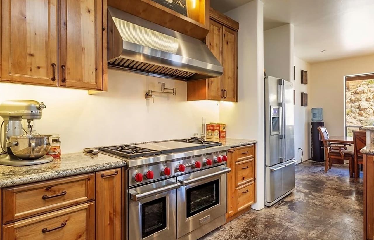 Aunque la decoración en madera clara da un aspecto rústico, hay elementos como los electrodomésticos de última generación que le dan un toque de modernidad debido a los materiales de acero inoxidable.