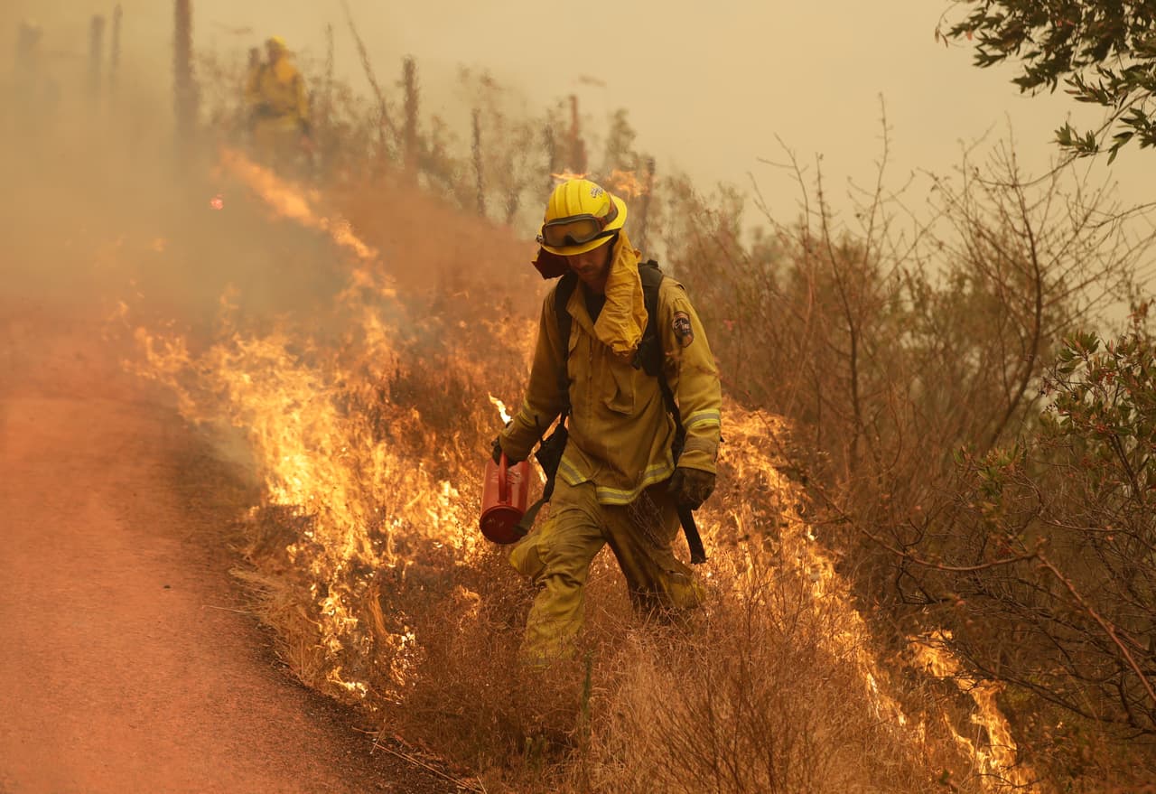 Un bombero camina por las llamas en una montaña de Sonoma, uno de los condados más afectados por los incendios. Al menos
<b> </b>40,000 personas todavía no pueden regresar a las zonas que siguen bajo amenaza.