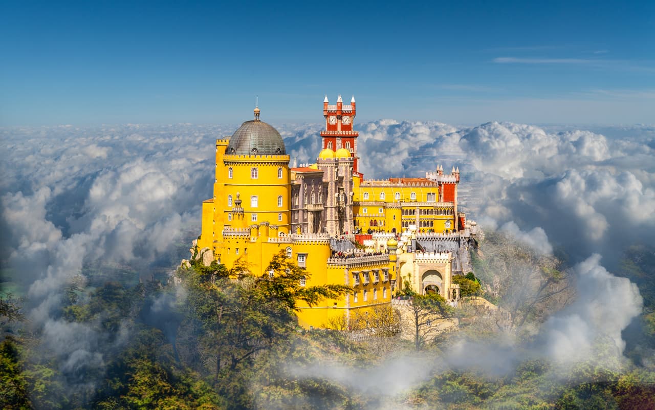 <b>Sintra, Portugal.</b> Es una ciudad ubicada en las afueras de Lisboa, la capital portuguesa. Es famosa por incluir un complejo de palacios y jardines además del Parque Natural Sintra-Cascais, cruzado por serranías desde cuyas cimas se alcanza a ver el mar. La ciudad es 
<a href="https://whc.unesco.org/en/list/723/" target="_blank">Patrimonio de la Humanidad declarado por UNESCO</a>. El complejo incluye un castillo medieval moro, el Palacio Nacional de Pena (en la foto) y el Palacio Nacional de Sintra. 
<br>
<br>