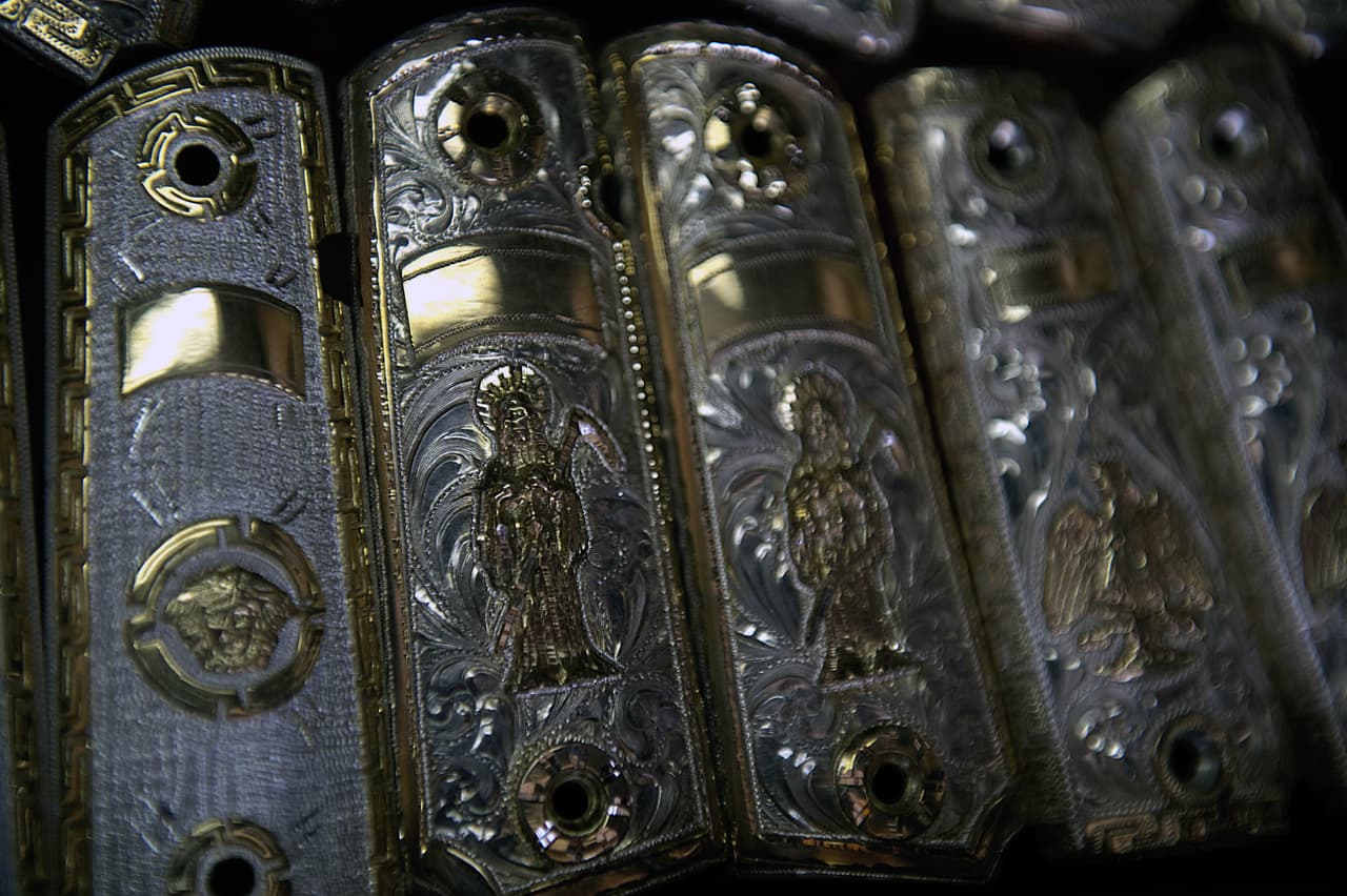 Las cachas de las armas lo mismo tienen imágenes de marcas como Versace que iconografía religiosa en materiales preciosos.
