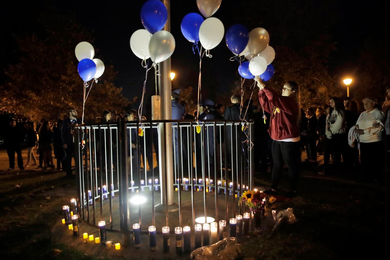 Jessica Dumont, exalumna de la secundaria Saugus, ata globos de helio en el Parque Central en honor a las víctimas del tiroteo, que también dejó a tres alumnos heridos, uno de los cuales ya recibió el alta médica.