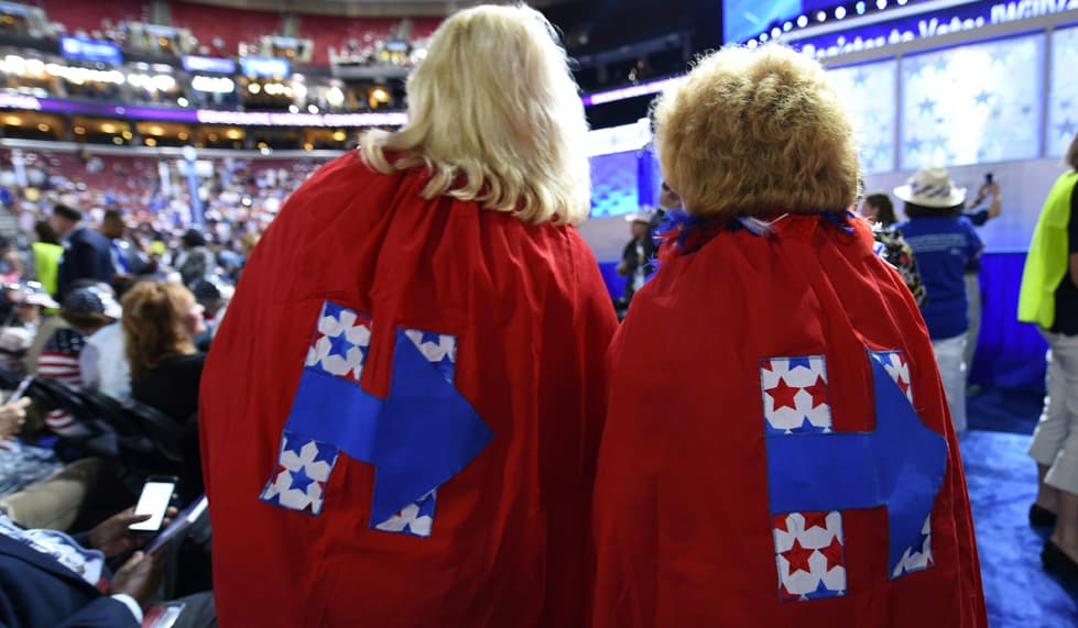 Con capas súper poderosas, como por arte de magia y con todos sus poderes para apoyara a Hillary Clinton, aparecieron estas dos mujeres. Sus capas rojas tienen el logotipo de la candidata.