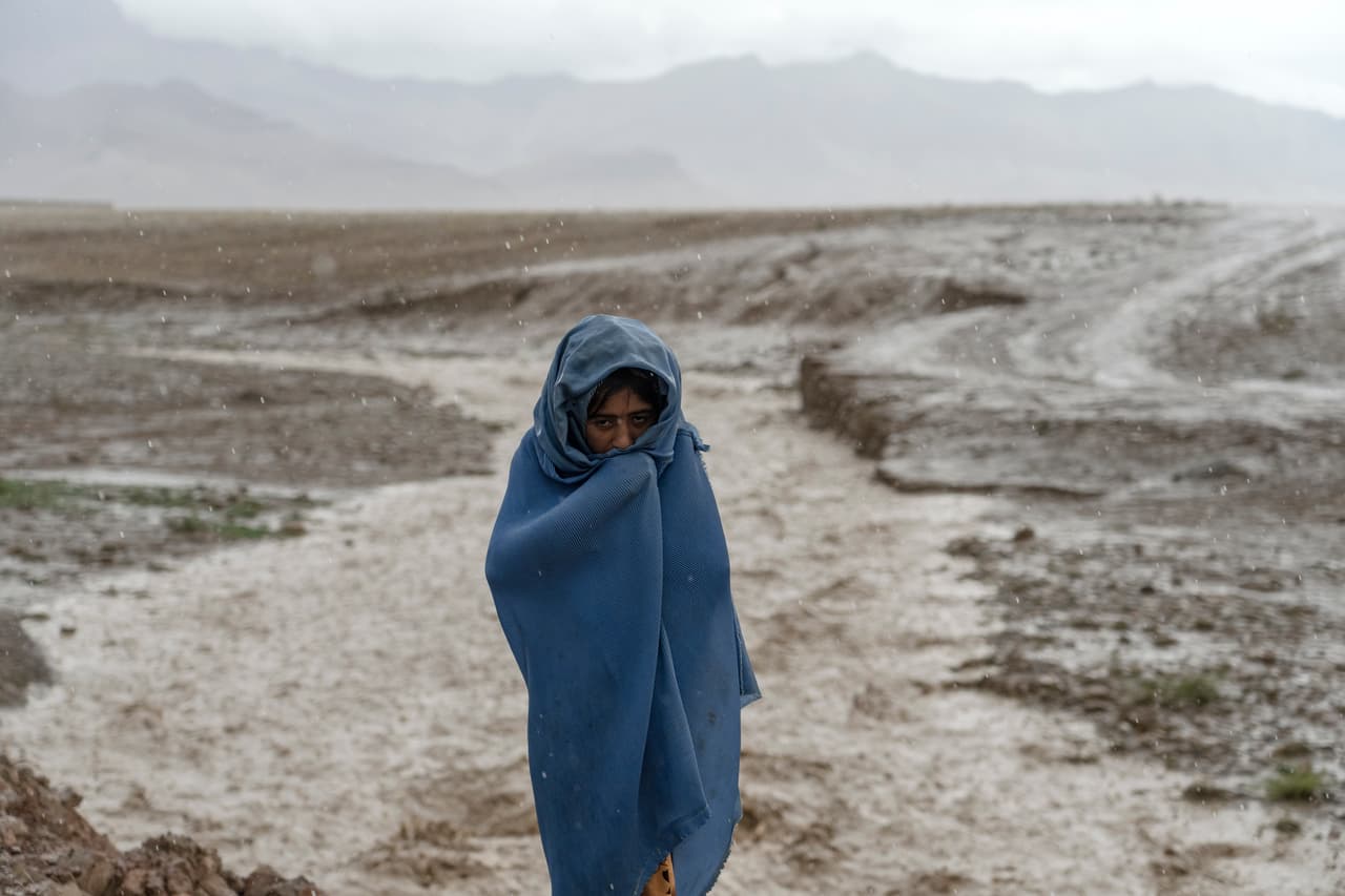 Una niña de 9 años trabaja bajo la lluvia. Una encuesta de la 
<a href="https://www.savethechildren.net/news/afghanistan-fifth-starving-families-sending-children-work-incomes-plummet-past-six-months" target="_blank">organización <i>Save the Children</i></a> estimó que 
<b>más de un millón de niños trabajan en Afganistán.</b>