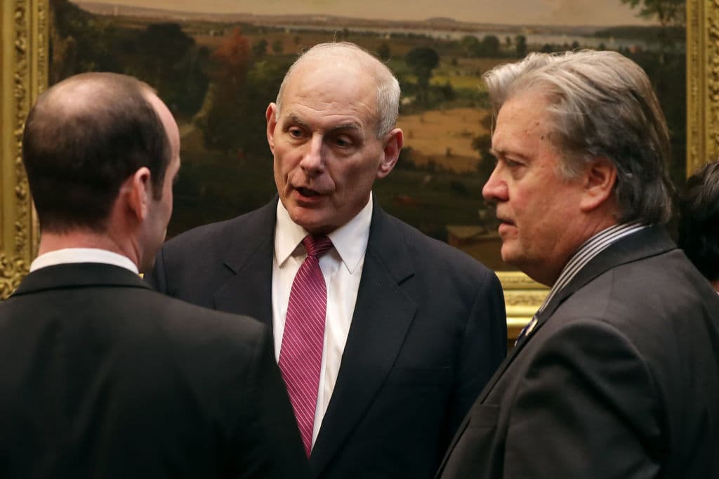 El secretario de Seguridad Nacional John Kelly (centro) habla con el estratega princial de la Casa Blanca Steve Bannon (der) y el consejero senior en políticas Stephen Miller (izq) antes de reunirse con el Presidente Donald Trump para hablar de ciber seguridad en la Casa Blanca el 31 de enero de 2017 en Washington, DC.