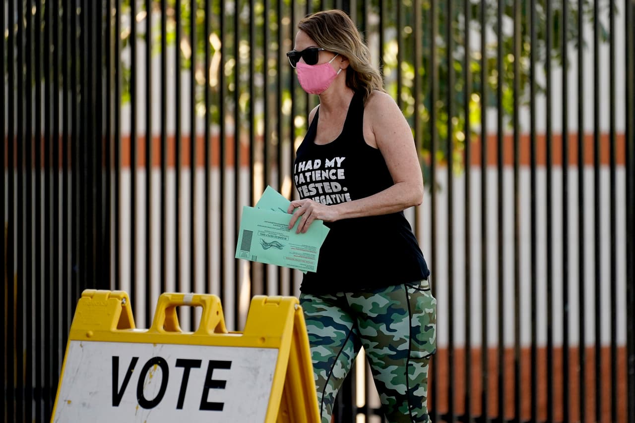 Una votante lleva su boleta temprana a un puesto de votación.