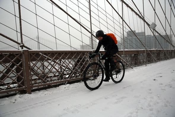 Un ciclista se esfuerza en recorrer el puente de Brooklyn debido a la nieve.