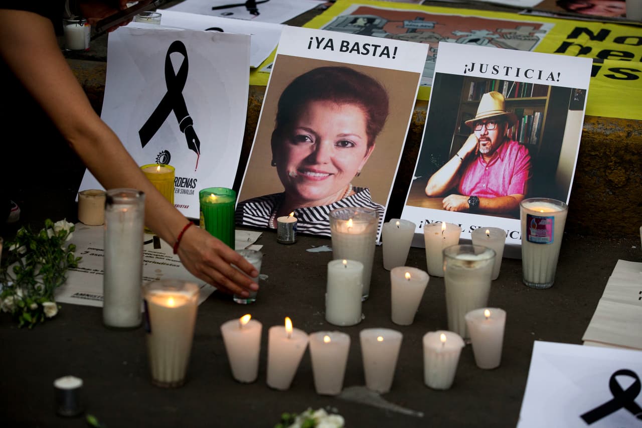 Mayo de 2017. Una mujer pone una vela frente a las fotografías de los periodistas asesinados Miroslava Breach, a la izquierda, y Javier Valdéz, durante una protesta las afueras de la secretaría de Gobernación en la Ciudad de México.