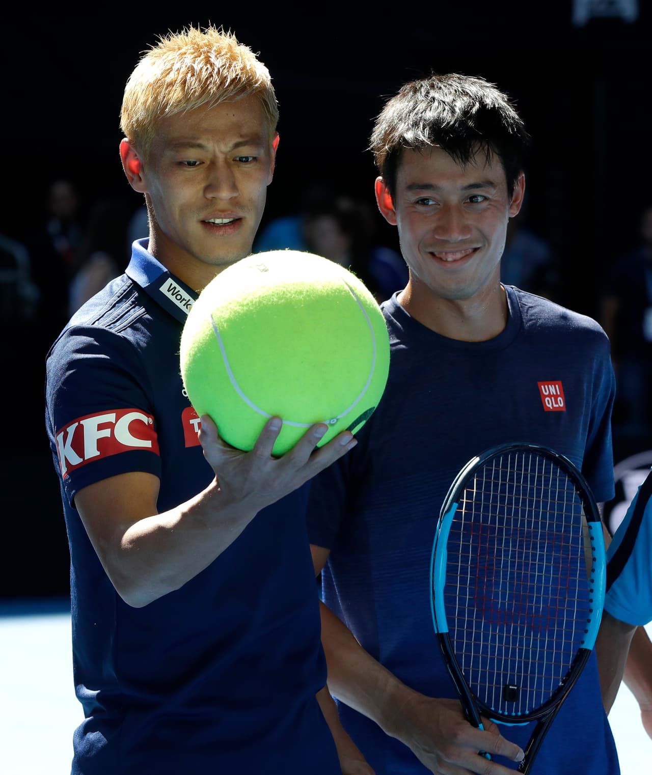 El tenista japonés Kei Nishikori (der.) recibió la visita de su compatriota Keisuke Honda (izq.), futbolista del Melbourne Victory y exjugador de Pachuca, con el que practicó y compartió previo al comienzo del Australian Open.