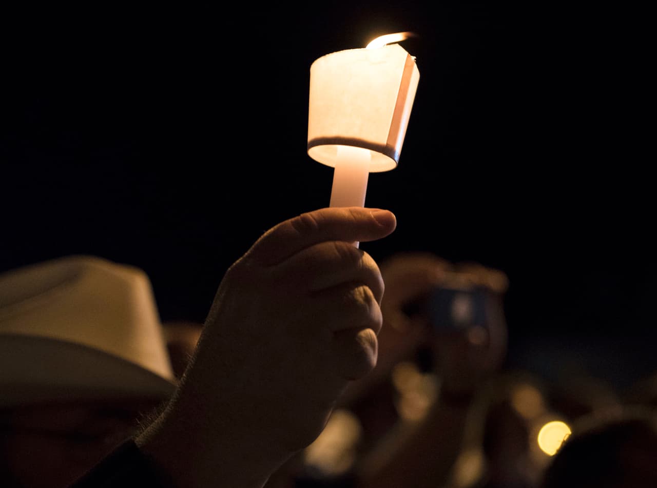 Un manifestante sostiene una vela durante una vigilia realizada para las víctimas del tiroteo.