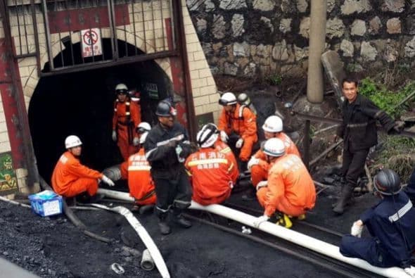 Los equipos de rescate descansan después de hacer el primer intento de salvar a los 22 mineros atrapados en una mina de carbón inundada en Qujing, provincia suroccidental china.