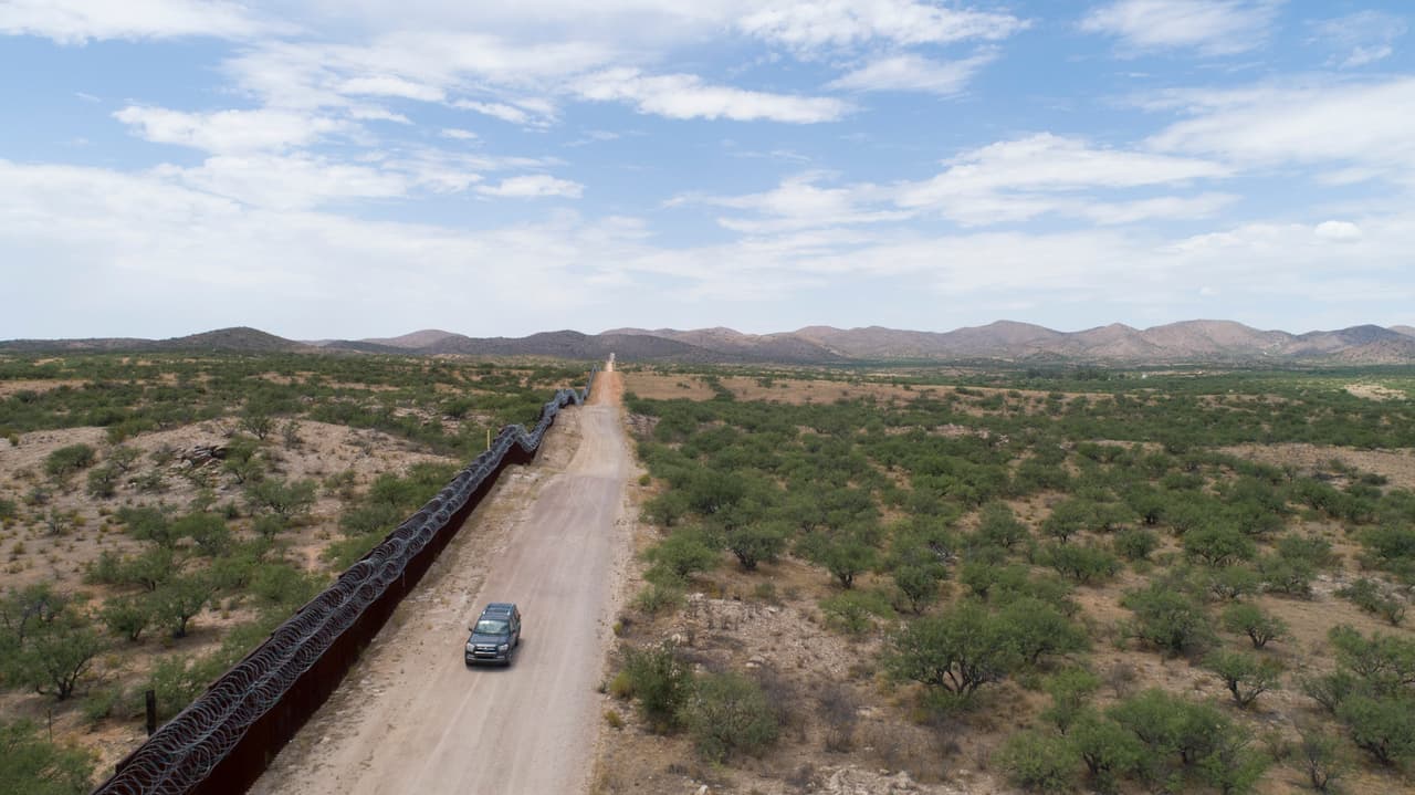 Una vista aérea de la frontera entre Estados Unidosy México. Una camioneta de voluntarios recorre la zona para ayudar a los migrantes deshidratados.