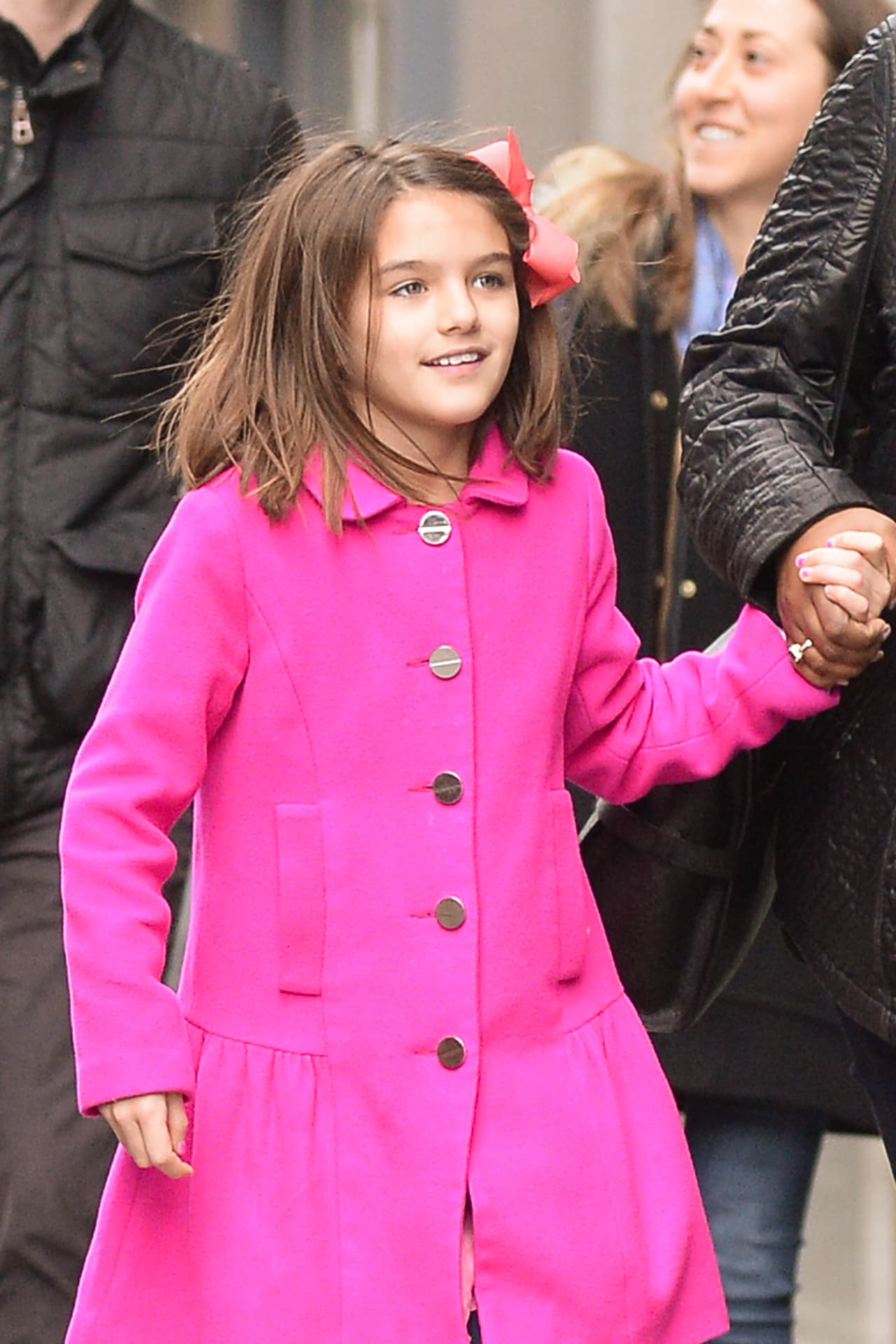 Suri Cruise salió a pasear con su nana, con un abrigo fucsia.