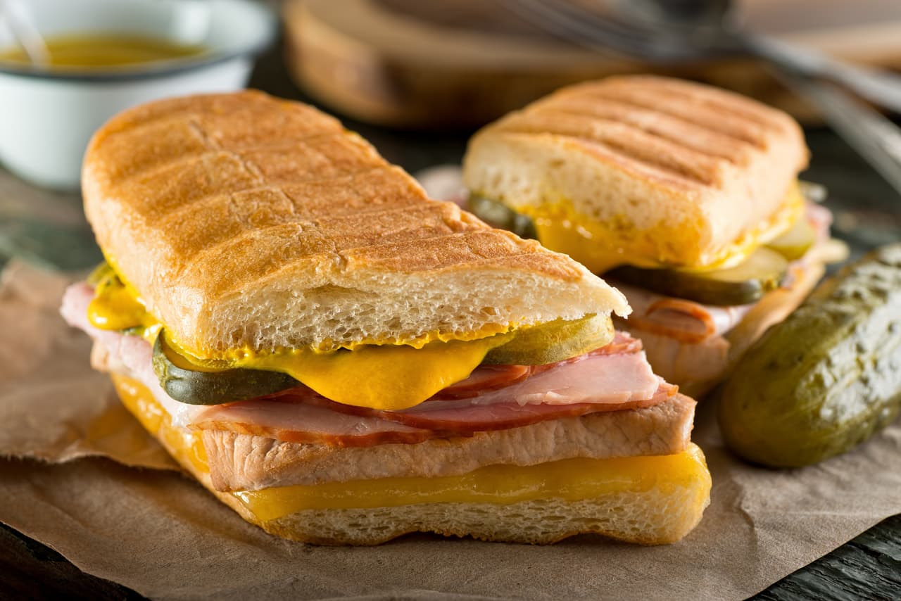 <b>Puesto 22. Cubano</b>
<br>
<br>Este sándwich está hecho con pan cubano relleno de jamón, cerdo asado, queso suizo, encurtidos y mostaza. Fue inventado por inmigrantes de Cuba en Florida, su propia variación de un clásico emparedado caribeño hecho con jamón y queso a la parrilla. El sándwich se prensa en la tostadora, lo que le da al pan una superficie crocante. 
<br>
<br>Hoy en día existen numerosas variaciones de este plato. Algunos usan diferentes panes o agregan ingredientes como lechuga, tomates y mayonesa.
<br>
<br>El portal de gastronomía Taste Atlas realizó una lista con los 
<a href="https://www.tasteatlas.com/50-best-rated-sandwiches-in-the-world"><u>50 sandwiches mejor calificados del mundo</u></a>. También recomienda los lugares donde puede darse el gusto de probarlos en Estados Unidos y otros países.