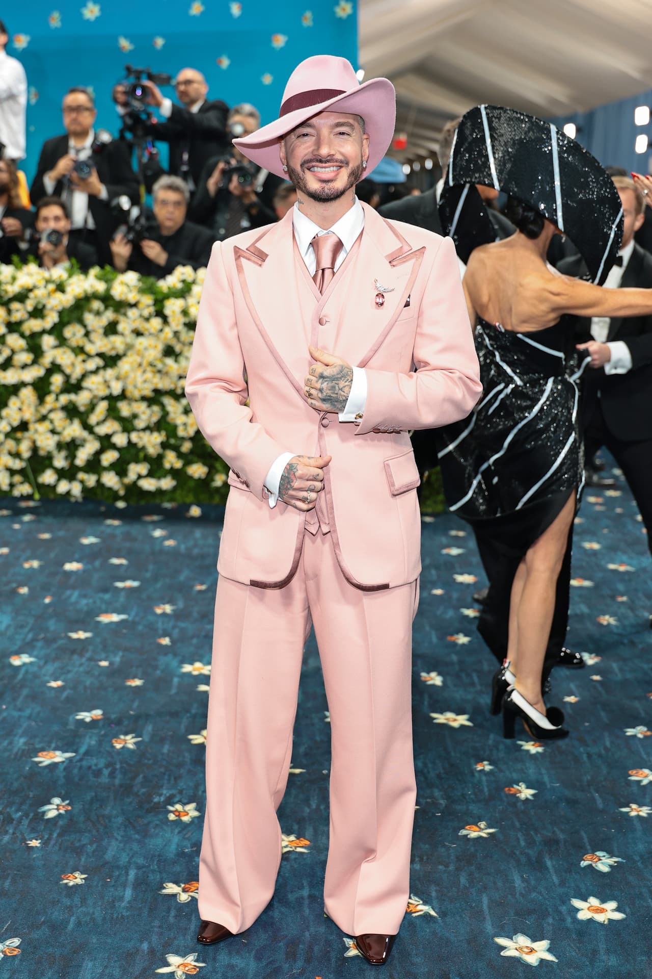 J Balvin atendió el prestigioso evento con un traje en tono rosa, el cual combinó con una camisa blanca y un sombrero ‘ad hoc’.