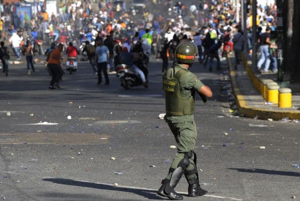 Un soldado apunta a un grupo de manifestantes.