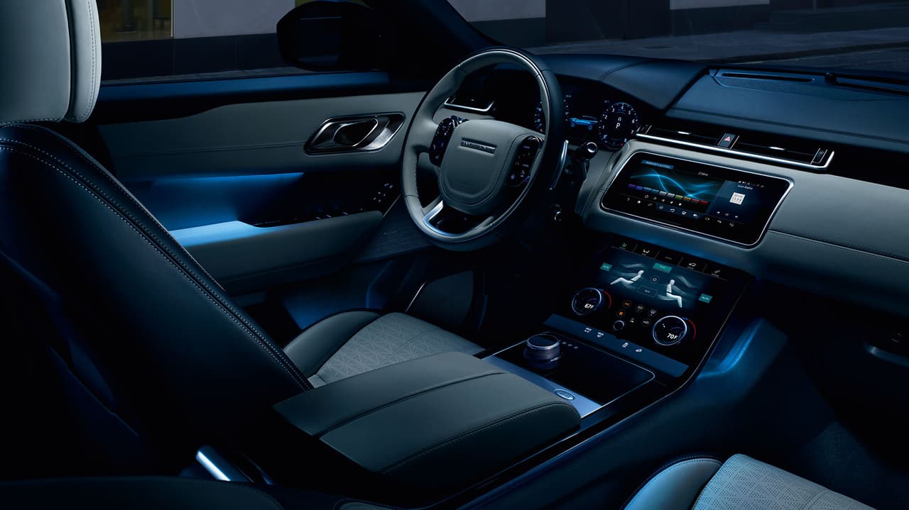 Esta hermosa imagen nocturna de la cabina de la Range Rover Velar 2018 muestra la luz de ambinete configurable opcional.
