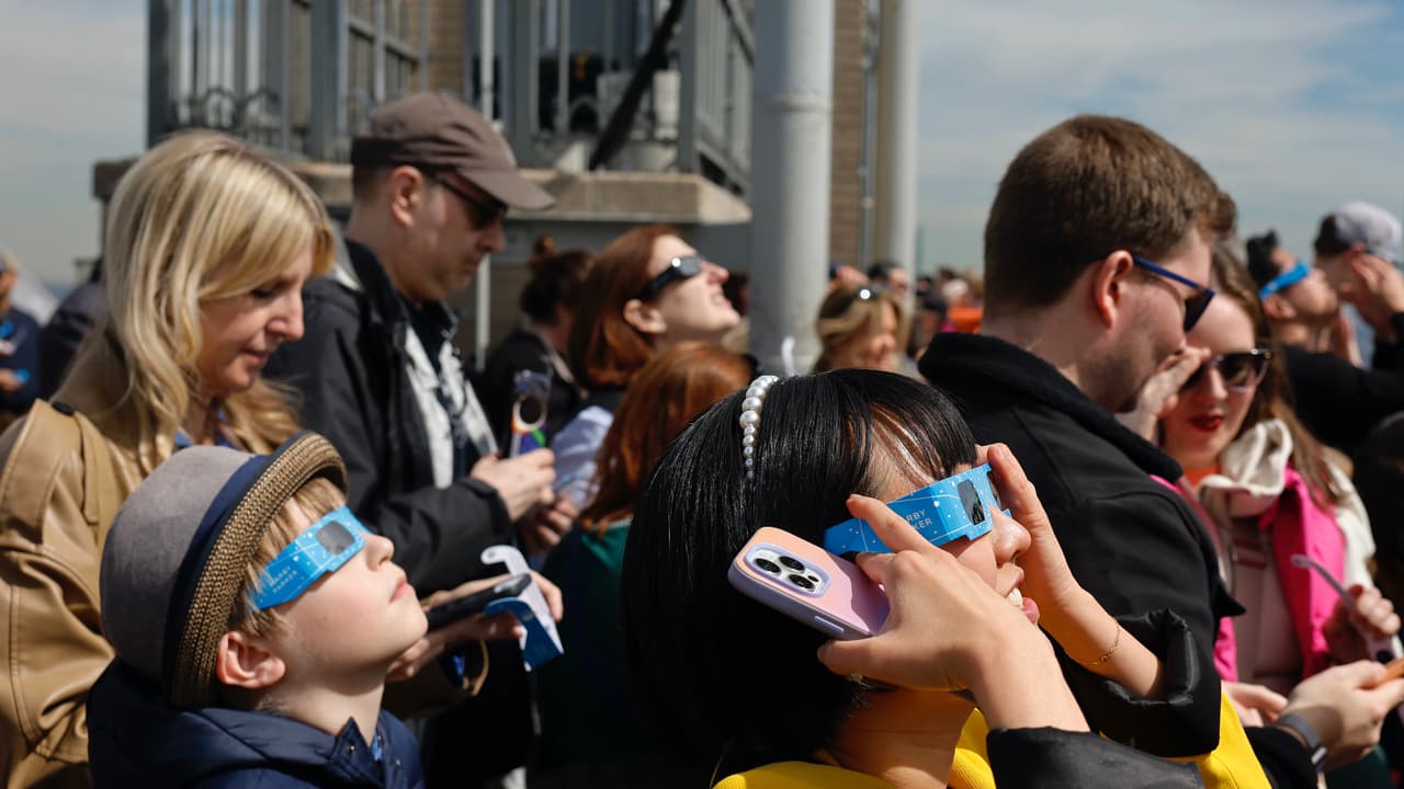 Turistas y locales disfrutan del desarrollo del eclipse solar sobre la cuidad de Nueva York, este lunes 8 de abril.