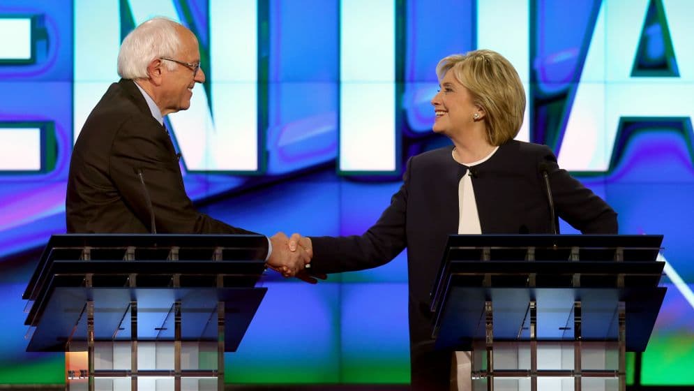 Sanders Clinton se dan la mano.