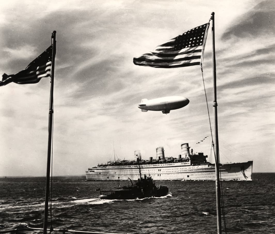 De 1940 a 1946 se le bautizó como el “Fantasma Gris” por el aspecto fantasmagórico que tenía al desaparecer entre la neblina matinal cuando partía desde Nueva York hacia el este cargado de soldados. Tal fue su aporte militar que Adolf Hitler ofreció una recompensa de 250,000 dólares al marinero que lograra hundir la embarcación y cortar así el flujo de tropas que reforzaban a su enemigo. El líder nazi no logró su objetivo.