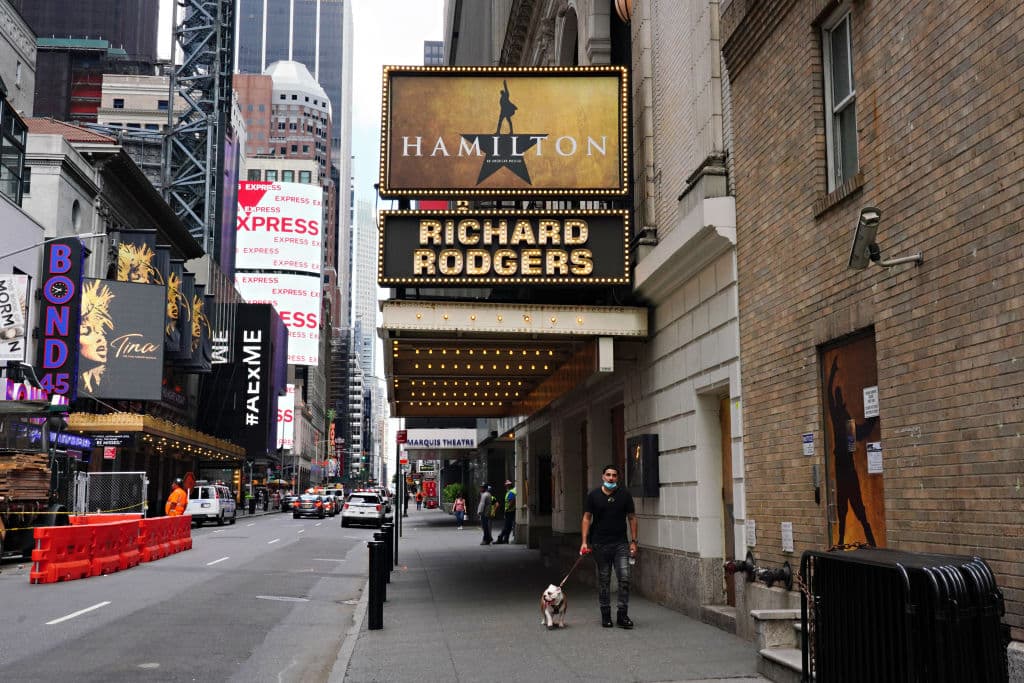 Una persona pasea a un perro bajo la marquesina de Hamilton: An American Musical en el Richard Rodgers Theatre, en la ciudad de Nueva York. Broadway permanecerá cerrado hasta 2021 debido a la pandemia de coronavirus.