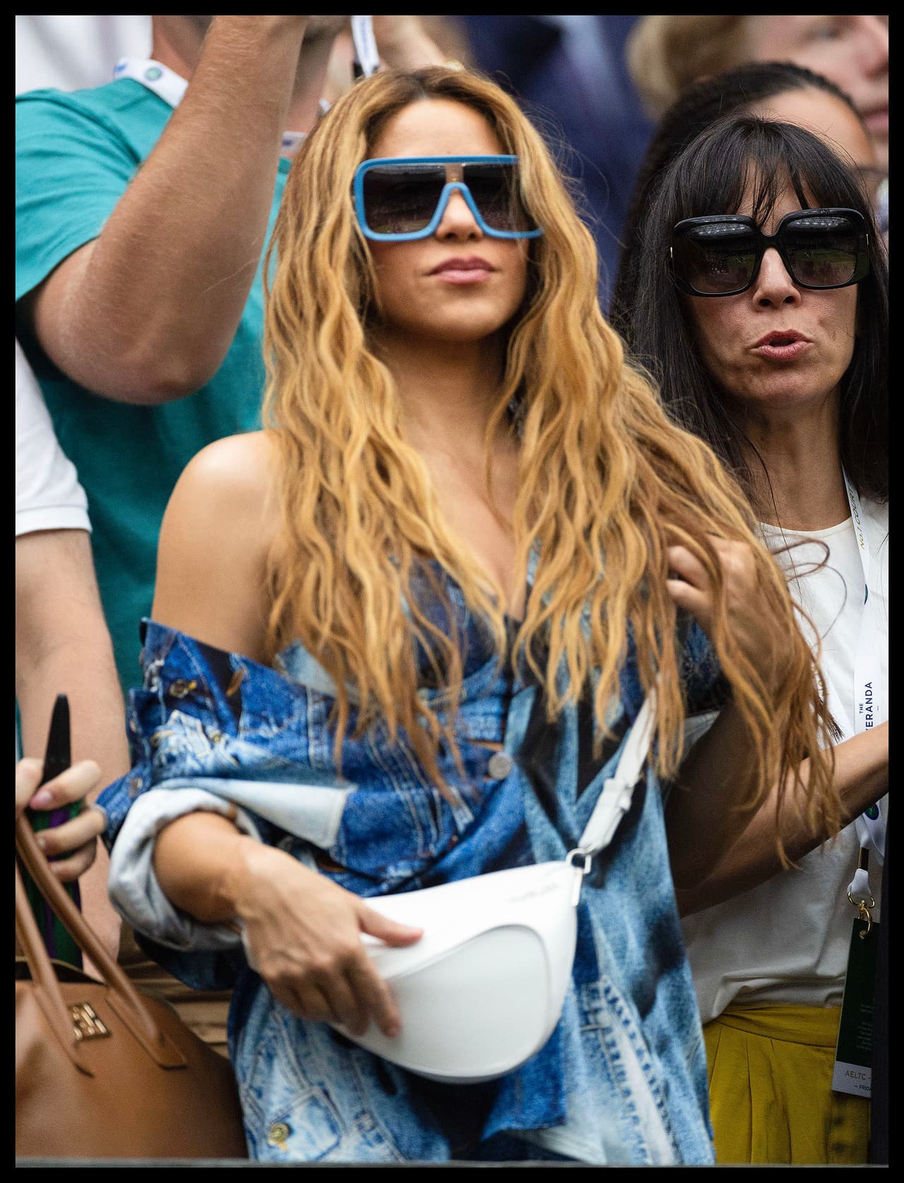 Usó unos tenis casuales en color azul con plataforma y un pequeño bolso blanco.
<br>