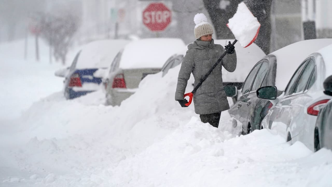Una mujer retira con una pala la montaña de nieve que cubre su auto en la mañana del jueves 17 de diciembre, en Manchester, New Hampshire. En este estado y en el sur de Maine la primera tormenta invernal dejó al menos un pie de nieve.