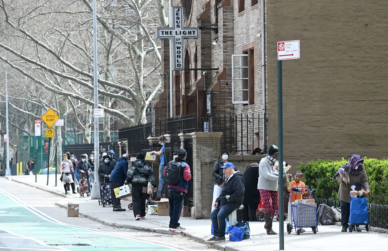 Grupo de personas hacen cola en la Misión de Covenant Mercy para recibir flores y alimentos. Varias son las iglesias al rededor de la ciudad que han estado ofreciendo comida a los neoyorquinos.