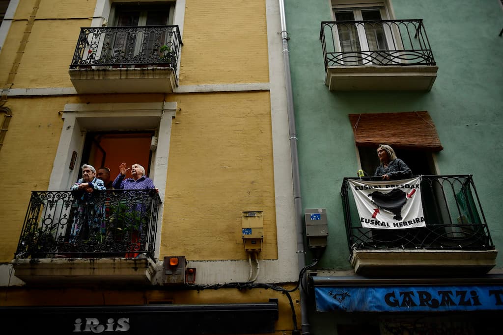 Los residentes en la ciudad vieja, Pamplona, norte de España, en sus balcones. El Ministerio de Sanidad español difundió recomendaciones a los más de 46 millones de españoles confinados: "Vístete, no te quedes en piyama", "evita la sobreinformación".