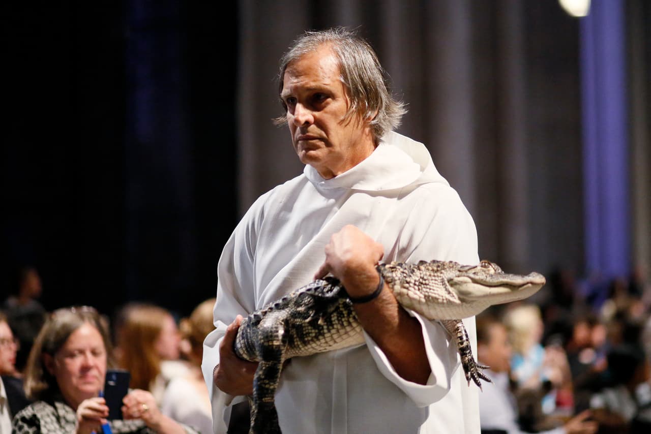 Un pequeño caimán es llevado para ser bendecido en la catedral St. John the Divine en New York.