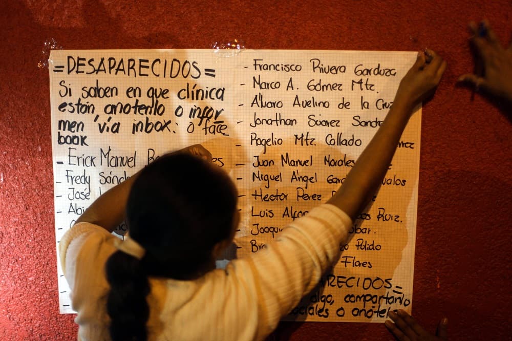Un familiar de una de las personas desaparecidas coloca una lista a las puestas de un hospital local de Coatzacoalcos.