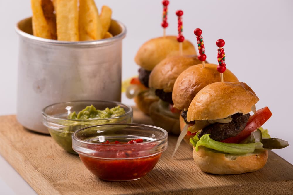 Mini hamburguesas Se ganaron un lugar por chiquitas, el sabor es de primer y lo mejor es que puedes comer las que necesites para sentirte satisfecho. Imagina bocados de carne sazonada con perejil, ají, queso americano y un ingrediente secreto que tú le puedes asignar.