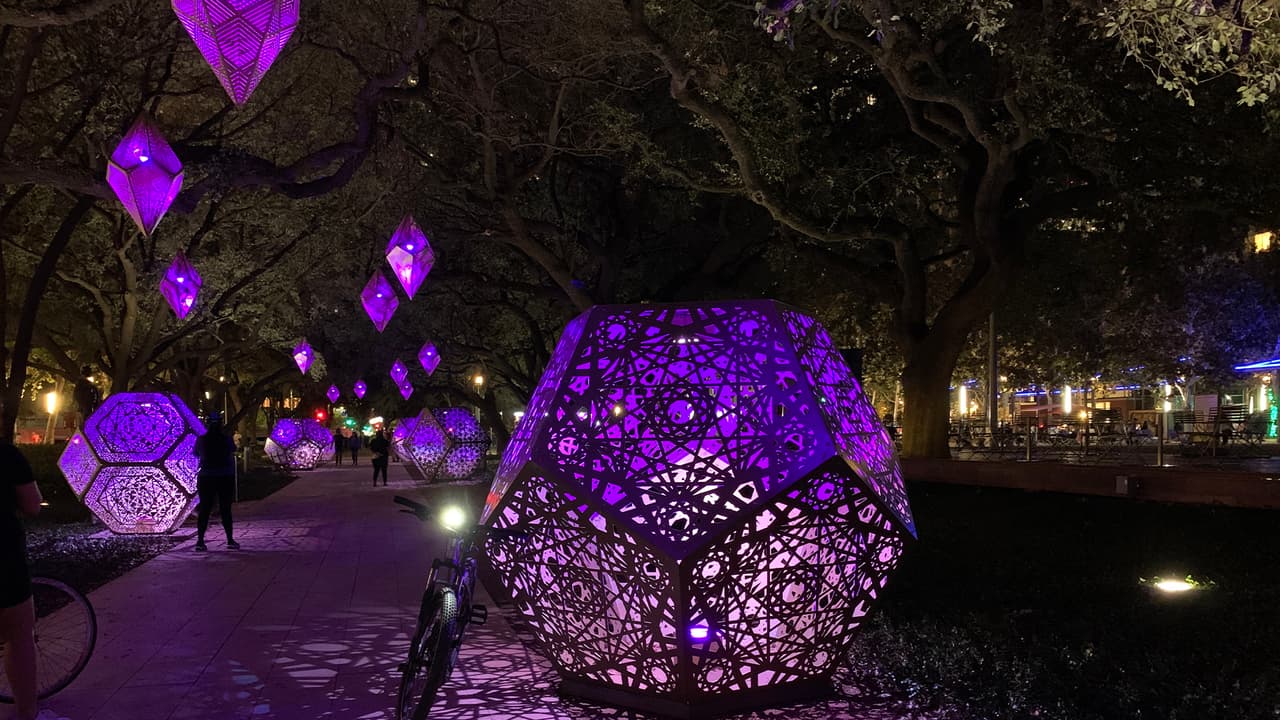 Las piezas también están colgadas en los voluminosos robles
<a href="https://www.univision.com/local/houston-kxln/luces-navidenas-the-woodlands-fotos">para iluminar</a> al interior del parque por donde camina la gente.