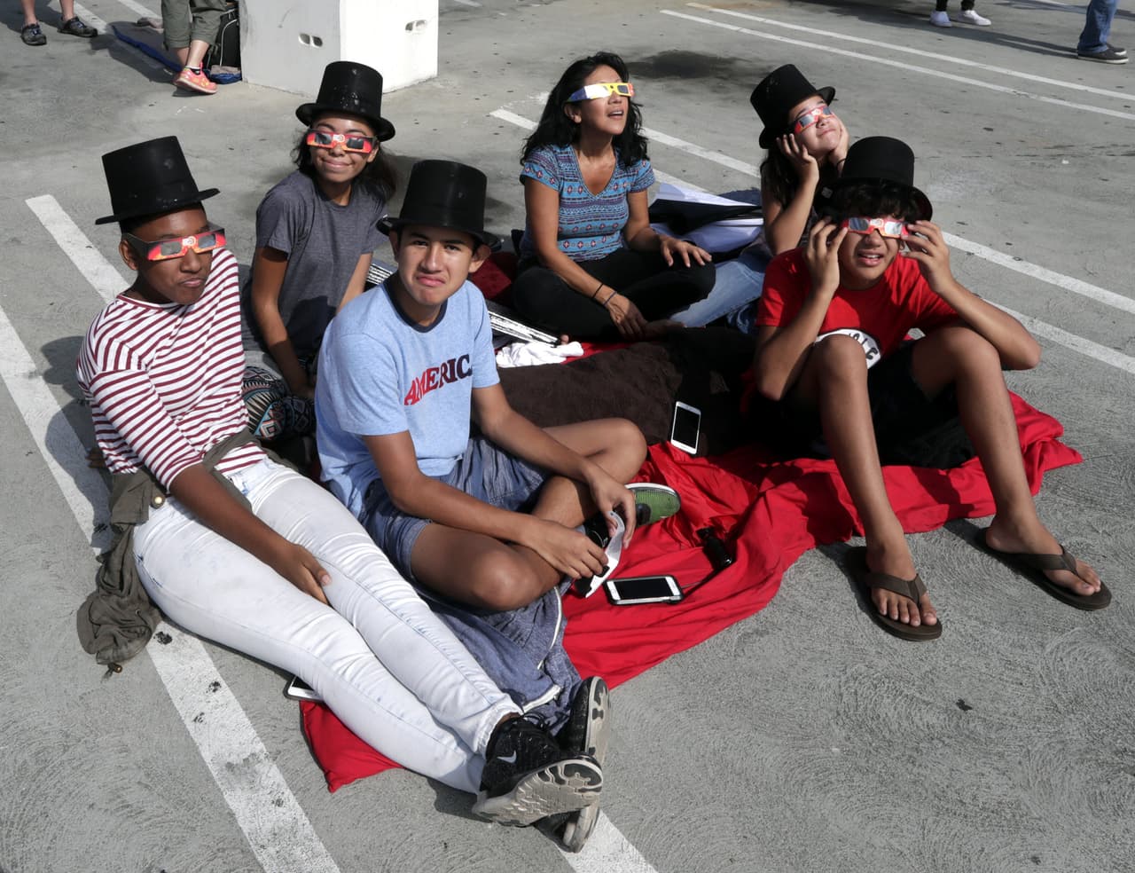 Una familia observa hacia el cielo durante el eclipse solar parcial en el Centro de Ciencias de California.