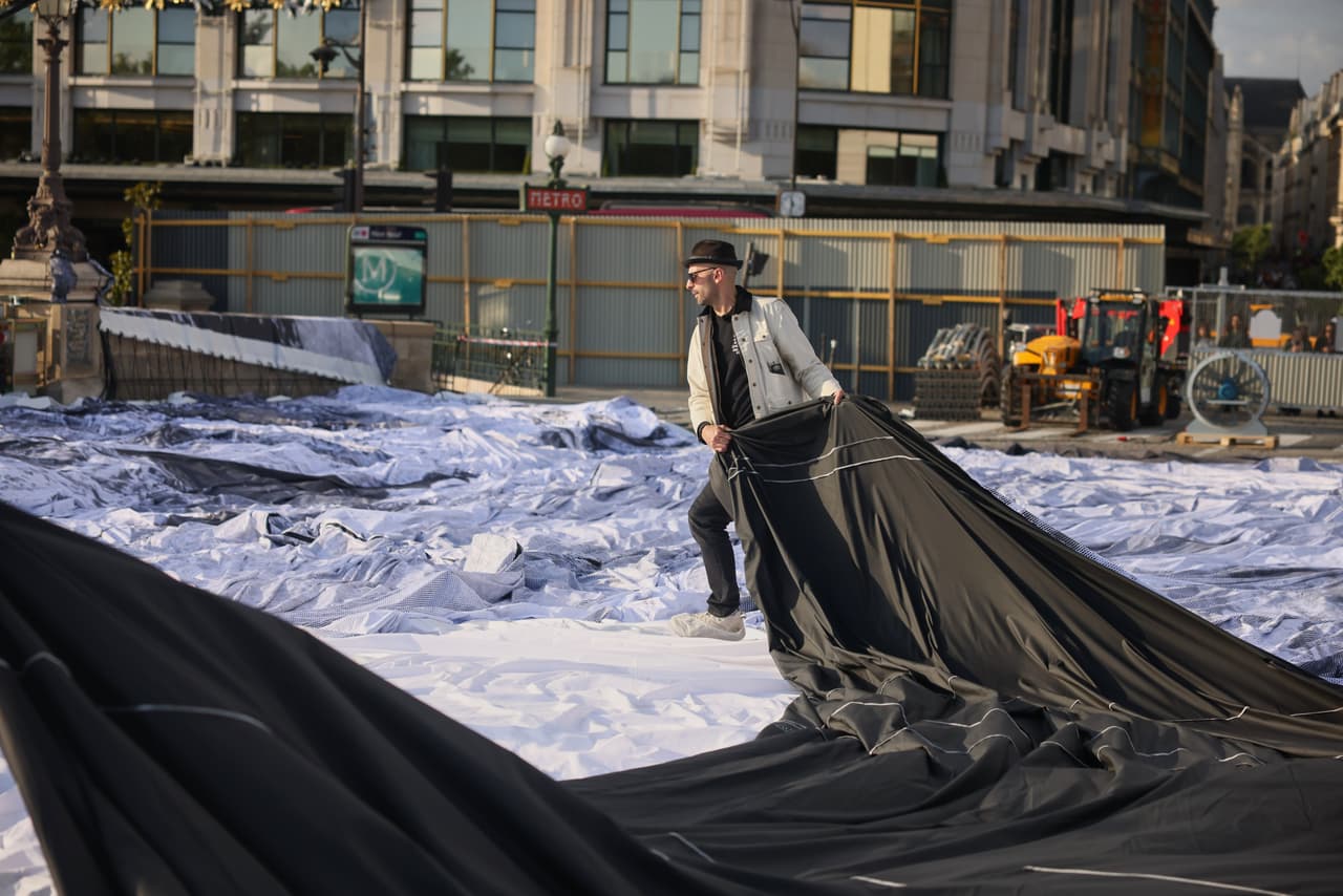 El artista callejero francés JR prepara el inflado de su obra "La cueva del Pont Neuf" en el puente Pont Neuf, el miércoles 20 de mayo de 2026, en París, antes de su inauguración gratuita para el público del 6 al 28 de junio. (Foto AP/Thomas Padilla)