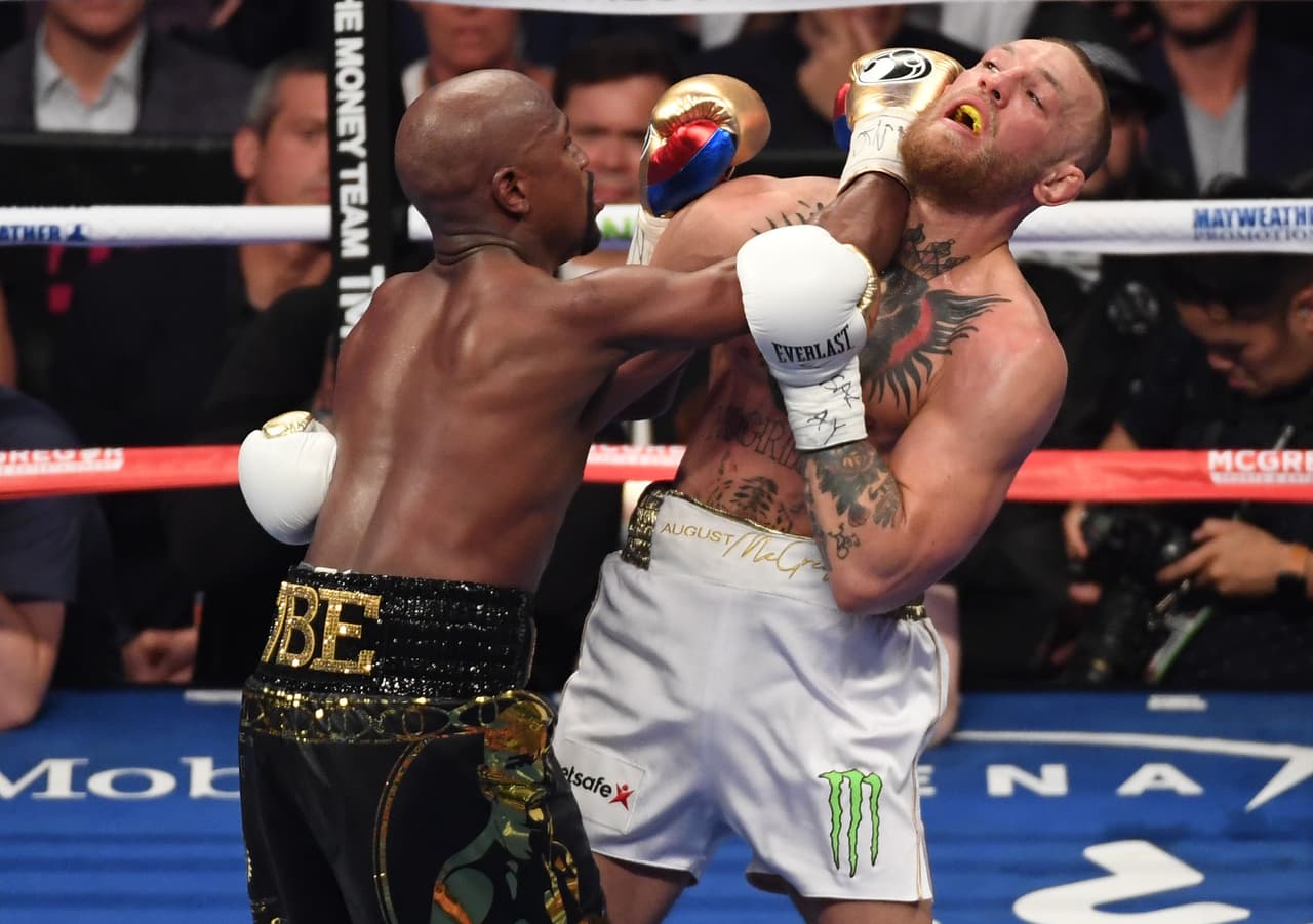 LAS VEGAS, NV - AUGUST 26: (L-R) Floyd Mayweather Jr. throws a punch at Conor McGregor during their super welterweight boxing match on August 26, 2017 at T-Mobile Arena in Las Vegas, Nevada. (Photo by Ethan Miller/Getty Images)