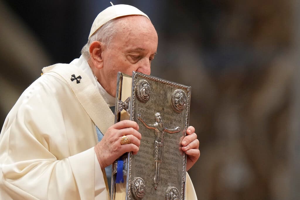 El papa Francisco besa el Libro Sagrado durante la misa de Año Nuevo, en la Basílica de San Pedro, en el Vaticano, el 1 de enero de 2022.