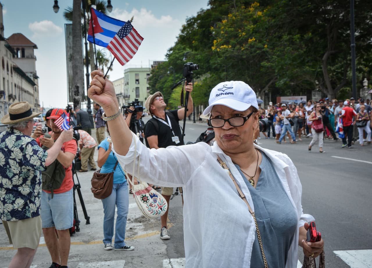 Una de las pasajeras del crucero Adonia llega a La Habana con banderas de EEUU y Cuba en la mano.