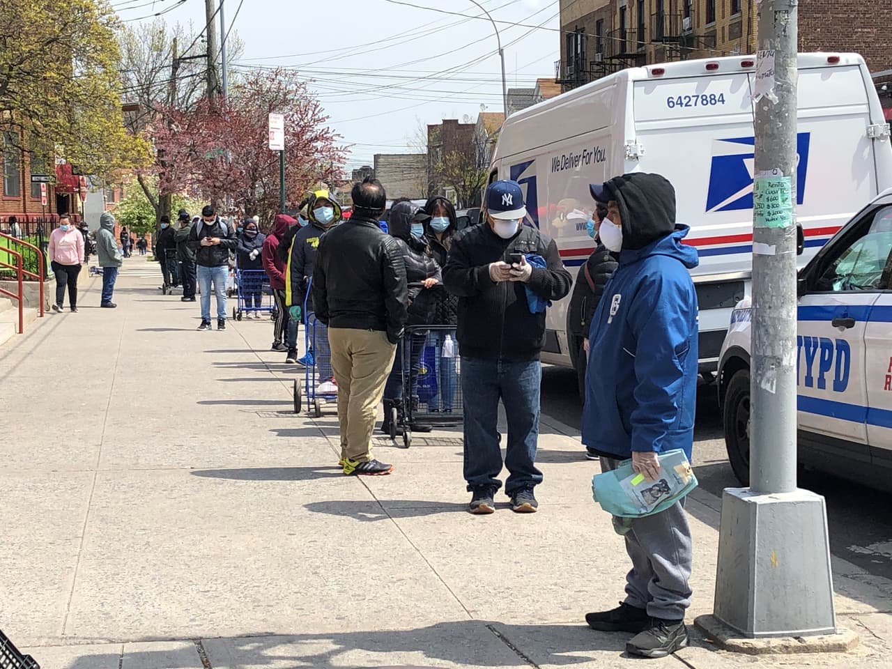 Decenas de 
<a href="https://www.univision.com/local/nueva-york-wxtv/filas-de-mas-de-20-cuadras-para-obtener-comida-la-realidad-de-miles-en-queens-en-tiempos-de-coronavirus">personas haciendo cola para recibir una caja de alimientos</a> durante el incio de la pandemia a las afuera de la iglesia católica Lady of Sorrows el 17 de abril, 2020, en Corona, Queens.