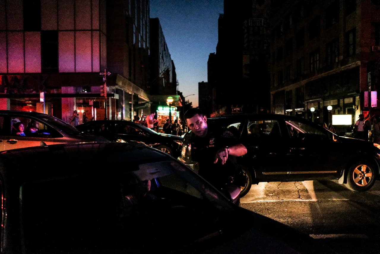 NUEVA YORK, NY - 13 DE JULIO: Los agentes de la policía de Nueva York dirigen el tráfico en la Avenida Ocho durante el apagón (Foto de Byron Smith/Getty Images)